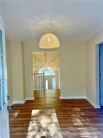 a view of a room with wooden floor a fireplace and a window