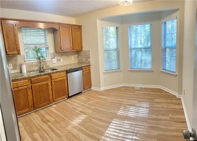 a view of a kitchen with kitchen island a sink wooden floor and a window