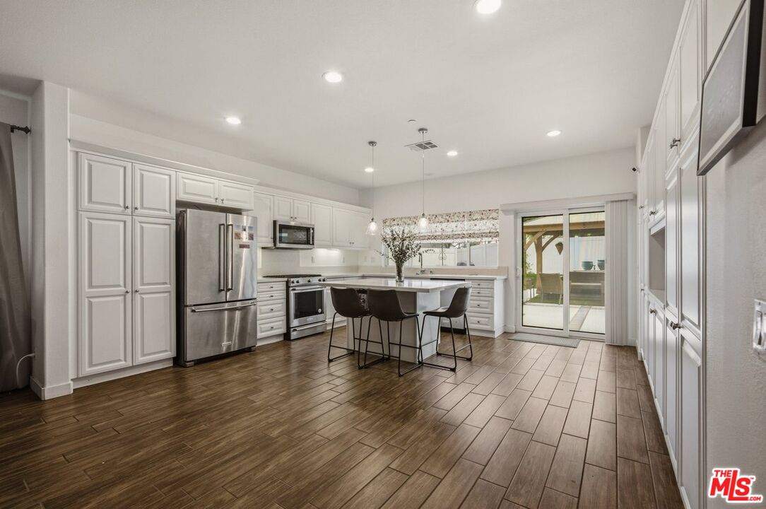 3065 Gibson Street Riverside, CA 92503 - Photo 10 of 15 an open kitchen with wooden floor and stainless steel appliances
