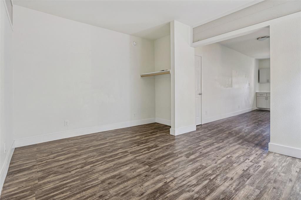 735 West 10th Street Dallas, TX 75208 - Photo 7 of 9 Bedroom with wood-look laminate floors — current rents significantly below market