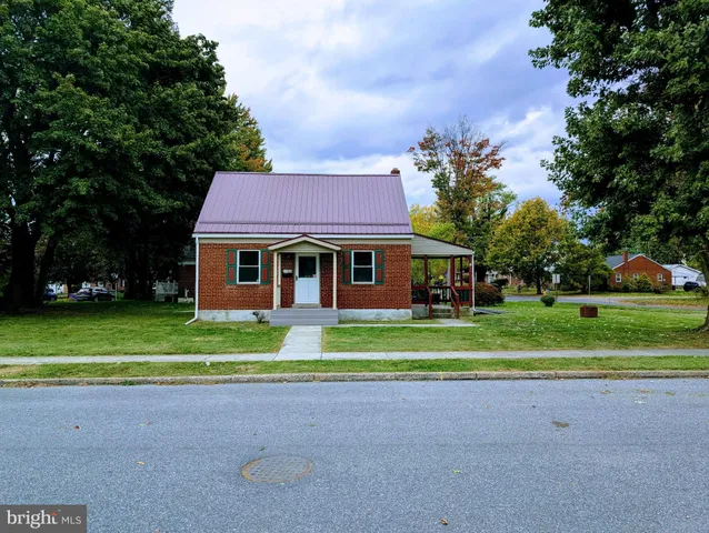 a front view of a house with a yard and trees