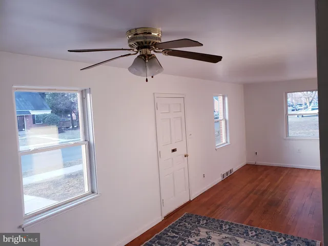 a view of a room with a ceiling fan and window