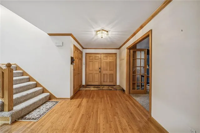 a view of a hallway with wooden floor and staircase