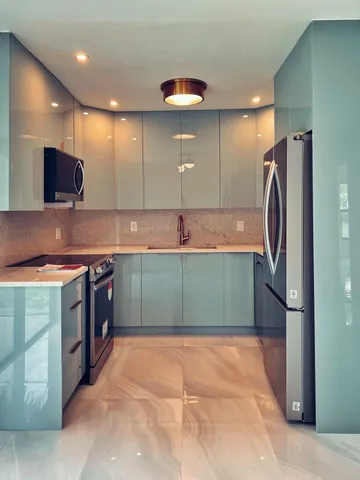 a kitchen with stainless steel appliances granite countertop a sink and a refrigerator