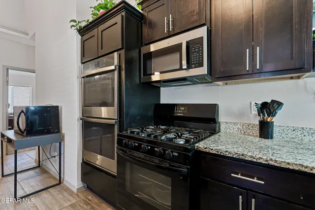 a kitchen with stainless steel appliances granite countertop a stove microwave and refrigerator