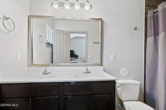 a bathroom with a sink vanity mirror and toilet