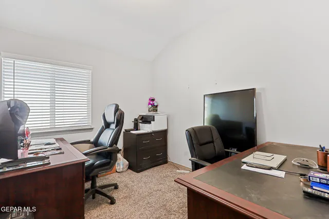 a view of a workspace with furniture and a window