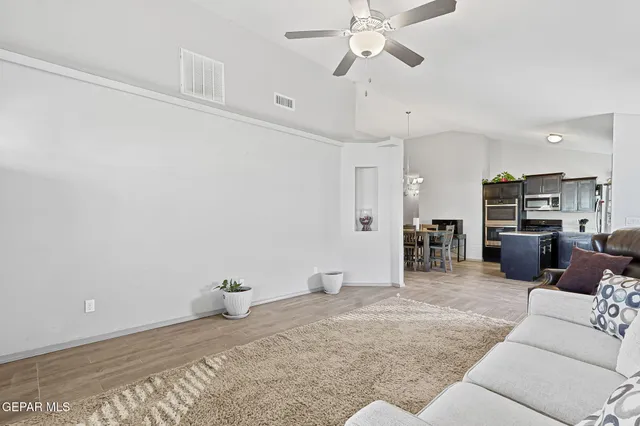 a living room with furniture and view of kitchen