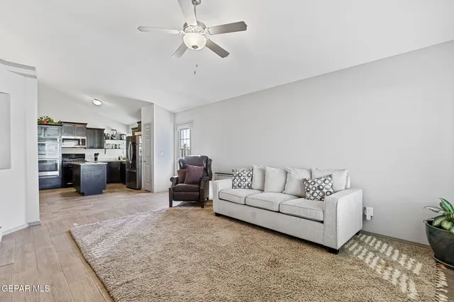 a living room with furniture and kitchen view