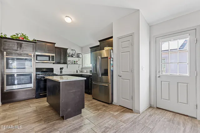 a kitchen with stainless steel appliances granite countertop a refrigerator stove and sink
