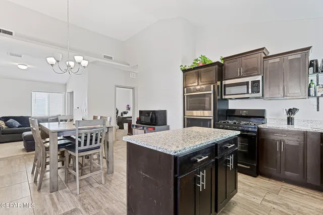 a view of kitchen with sink dining table and chairs