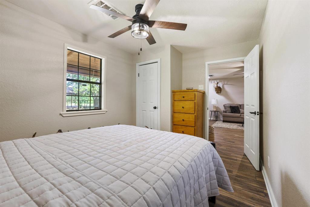 2042 East 1980 Road Antlers, OK 74523 - Photo 23 of 33 a bedroom with a bed and a chandelier