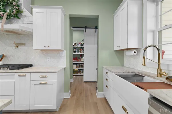 a kitchen with granite countertop a sink stove and cabinets