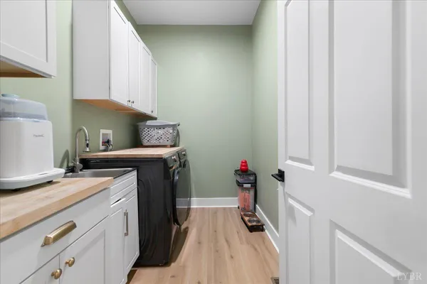 a view of a kitchen with fridge and wooden floor