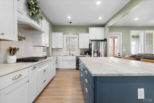a large kitchen with kitchen island a sink stainless steel appliances and cabinets
