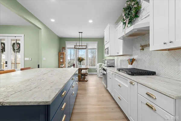 a large kitchen with stainless steel appliances granite countertop a lot of counter space and wooden floors