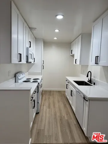 a kitchen with granite countertop a sink stove and cabinets