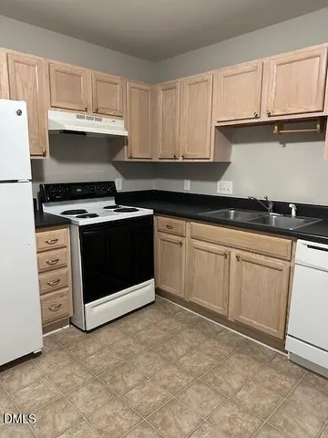 a kitchen with granite countertop a stove sink and cabinets