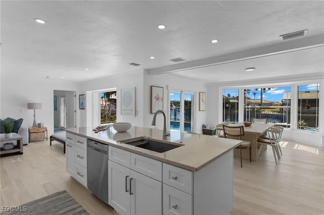 a kitchen with kitchen island granite countertop lots of counter top space a sink stainless steel appliances and cabinets