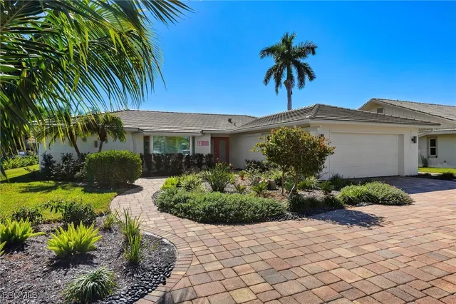 a view of a house with a yard and potted plants