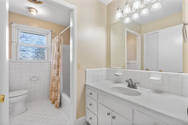 a bathroom with a sink a toilet and a large mirror