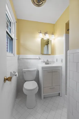 a bathroom with a toilet sink and mirror