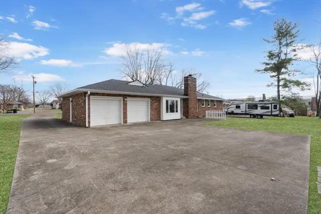 a front view of a house with garden and trees