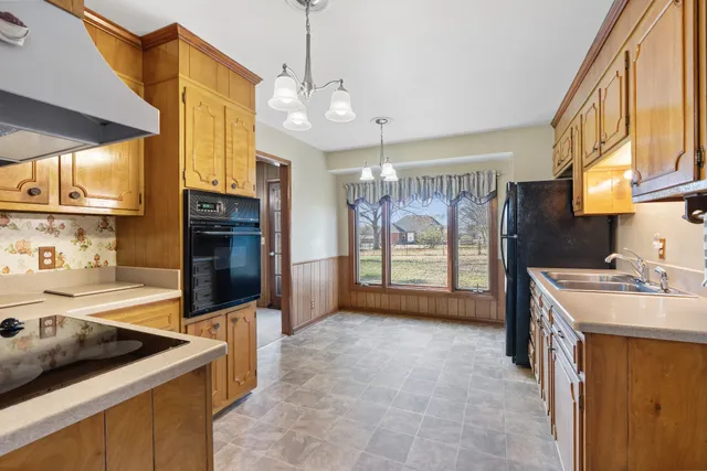 a kitchen that has a lot of cabinets and wooden floor