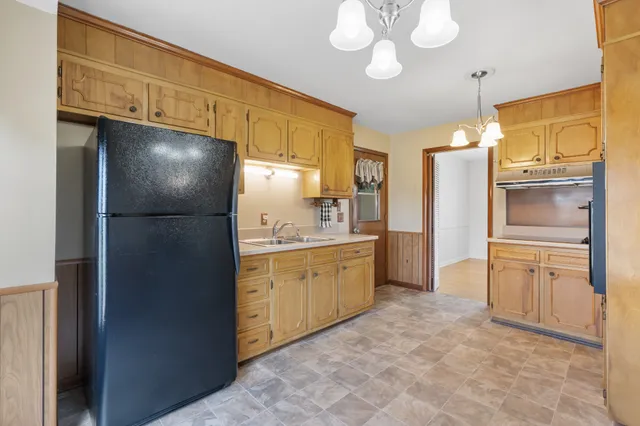 a kitchen with granite countertop stainless steel appliances a refrigerator a sink and cabinets