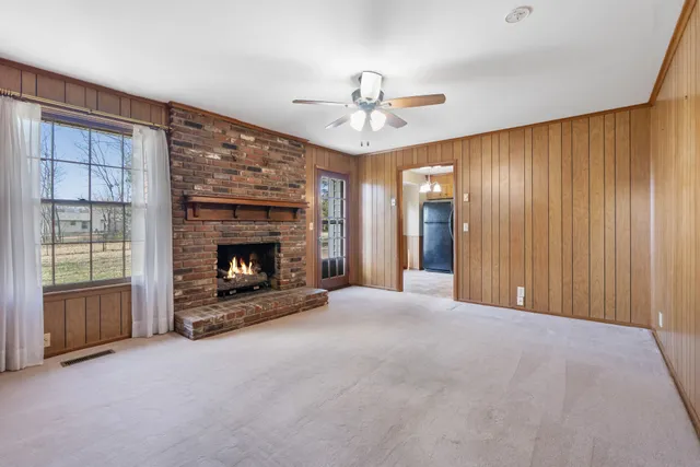 a view of an empty room with a fireplace and a window