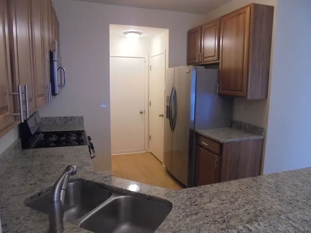 a kitchen with granite countertop white cabinets and stainless steel appliances
