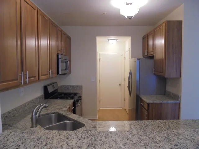 a kitchen with stainless steel appliances granite countertop a sink refrigerator and microwave