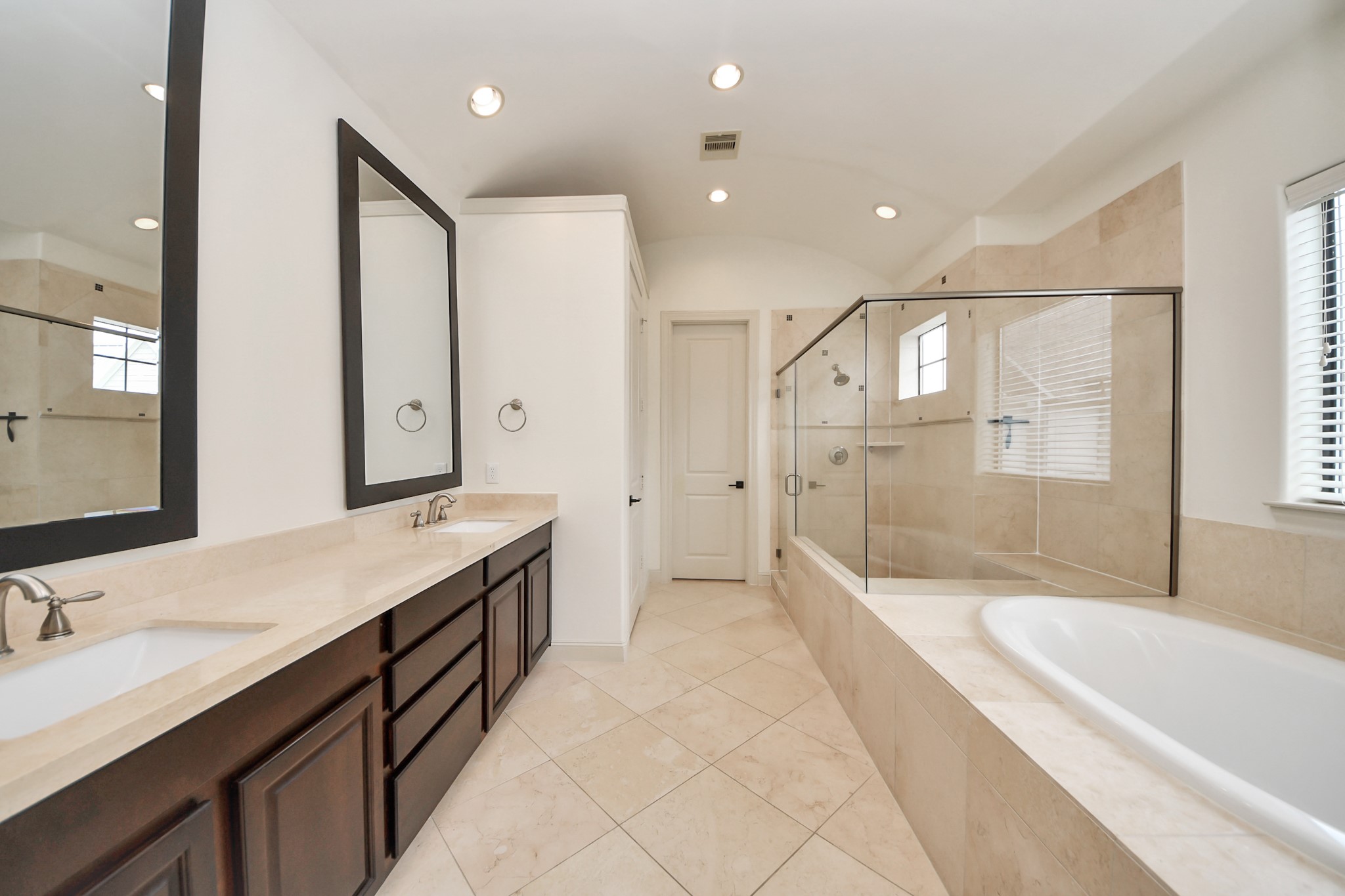 3229 Maxroy Street Houston, TX 77008 - Photo 4 of 43 A spacious primary bathroom featuring a double vanity with plenty of storage, a large soaking tub, and a big glass-enclosed shower equipped with a built-in seat.