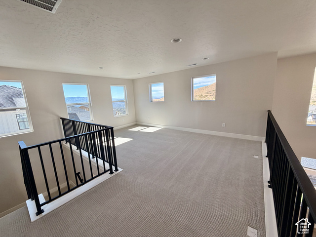 1595 West Canyon Rim Road, Unit 630 Lehi, UT 84048 - Photo 23 of 41 Open loft area featuring neutral carpeting, recessed lighting, multiple windows, and a black metal railing