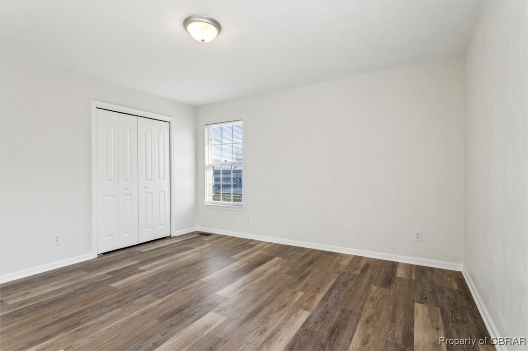 111 Pleasant Spring Avenue Waverly, VA 23890 - Photo 24 of 32 Unfurnished bedroom with dark hardwood / wood-style floors and a closet