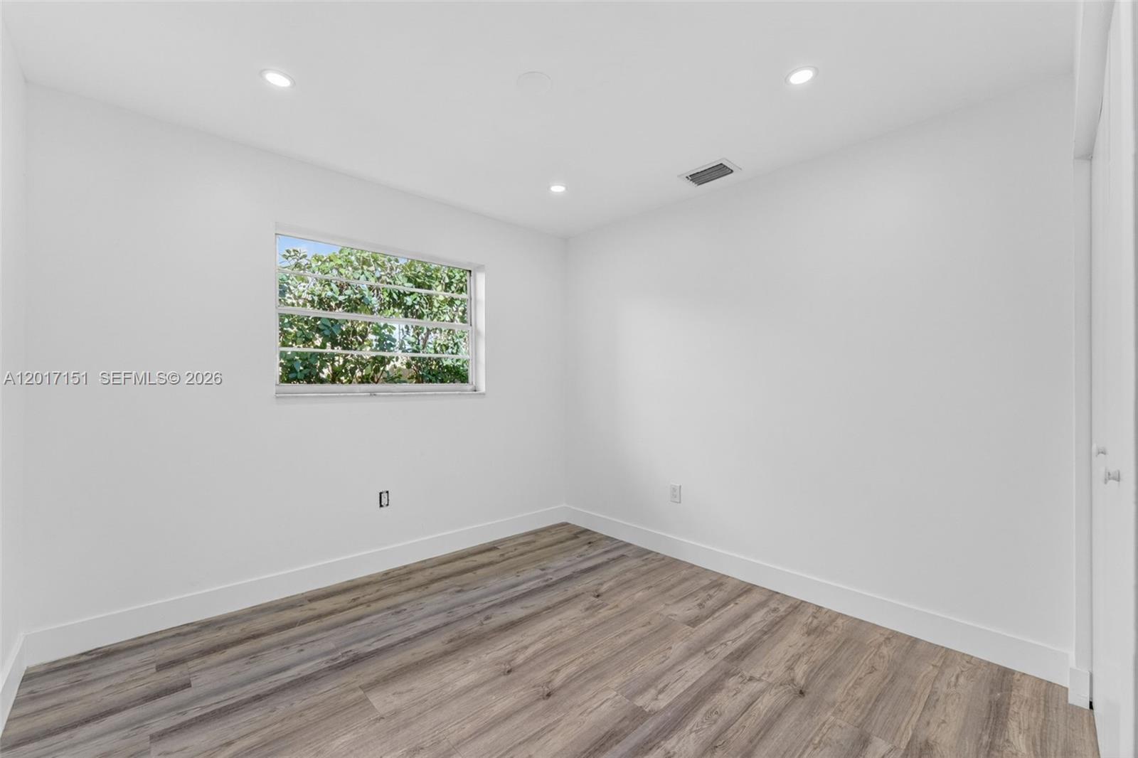 10210 Southwest 175th Street Miami, FL 33157 - Photo 17 of 25 an empty room with wooden floor and window