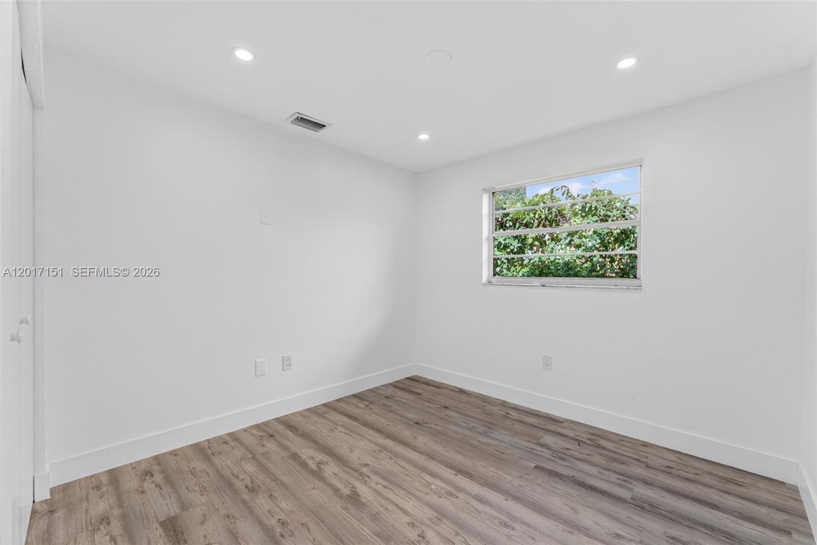 10210 Southwest 175th Street Miami, FL 33157 - Photo 20 of 25 an empty room with wooden floor and window