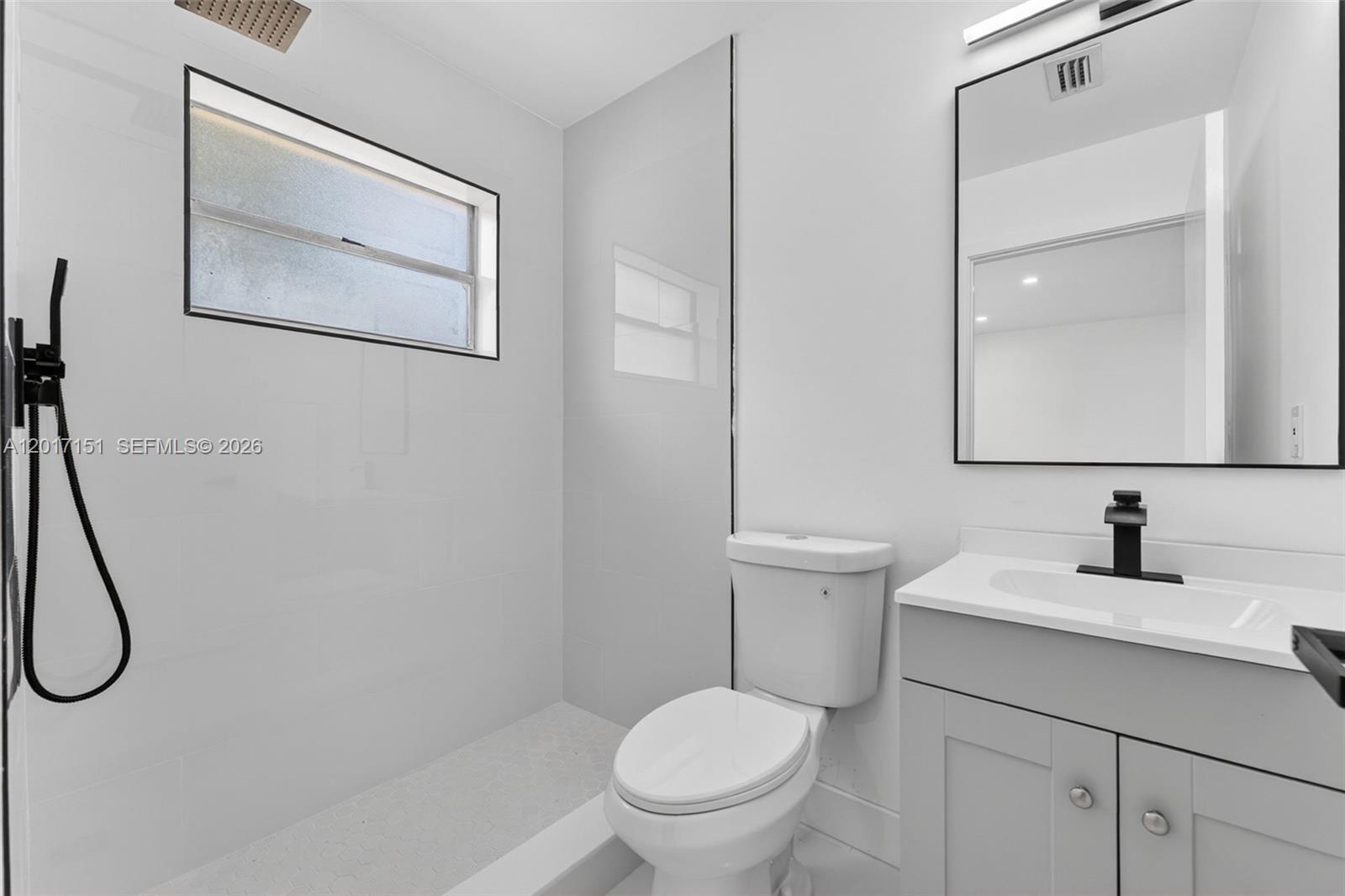 10210 Southwest 175th Street Miami, FL 33157 - Photo 9 of 25 a bathroom with a toilet sink vanity and mirror