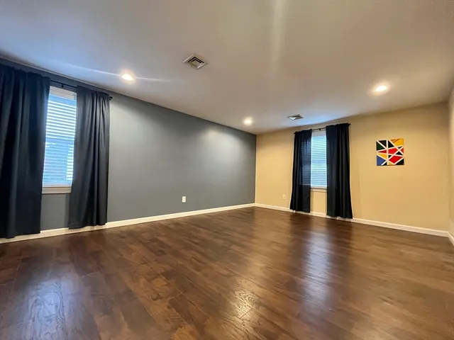 a view of an empty room with wooden floor