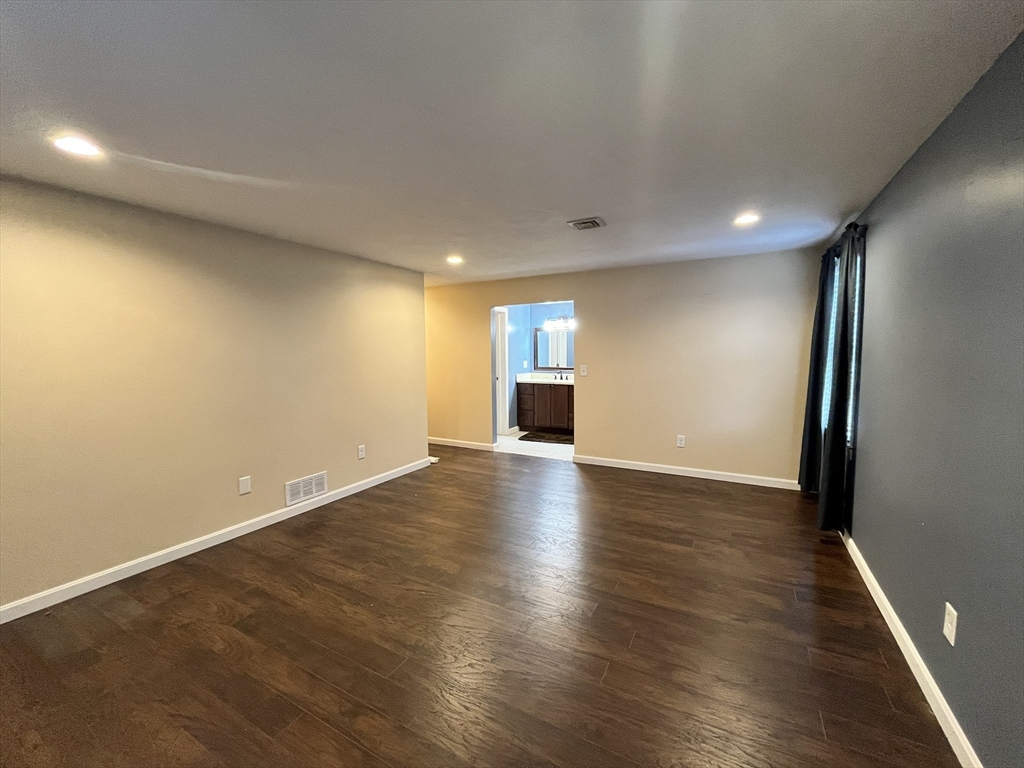 1830 Main Street, Unit 21 Tewksbury, MA 01876 - Photo 13 of 15 an empty room with wooden floor and windows