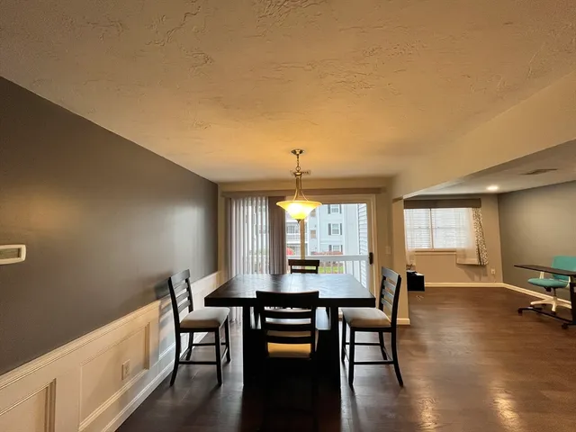 a view of a a dining room with furniture window and wooden floor