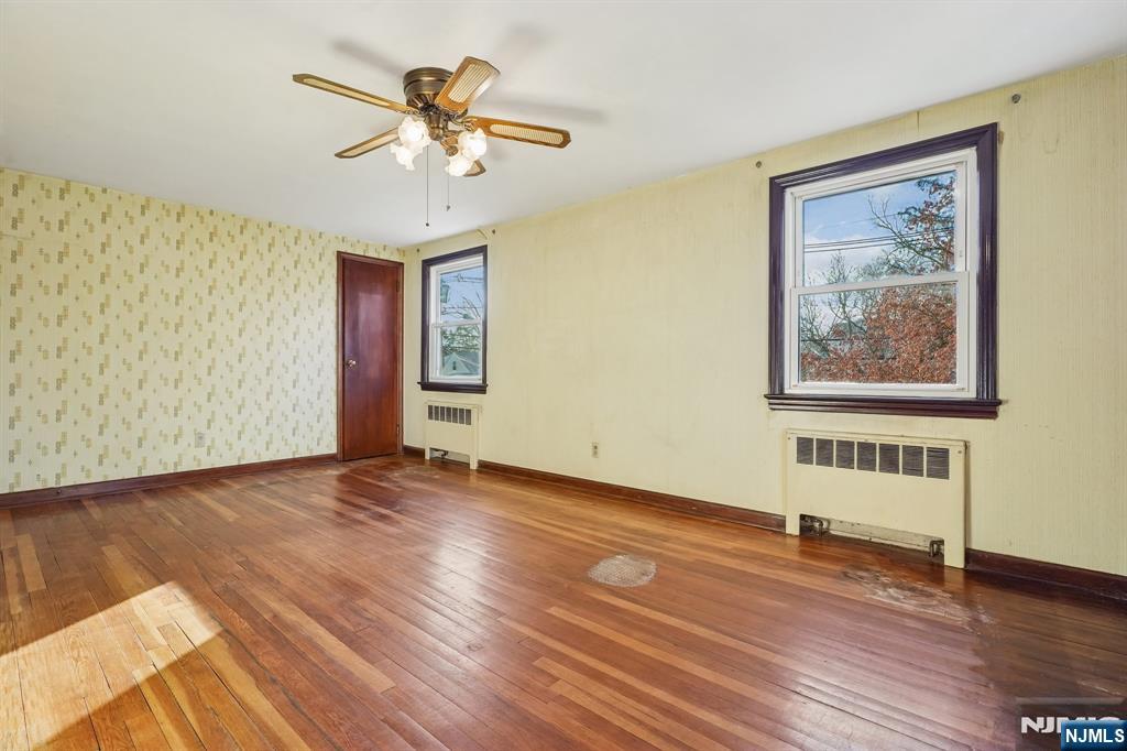 404 Burroughs Terrace Union, NJ 07083 - Photo 12 of 19 a view of an empty room with wooden floor and a ceiling fan