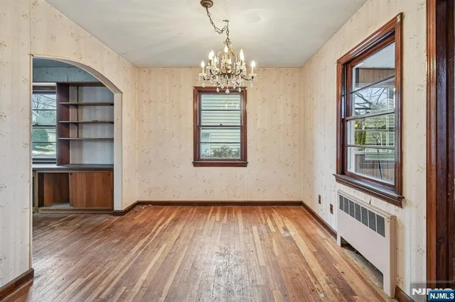 a view of a room with wooden floors and entryway