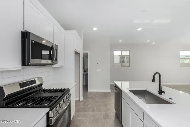 a kitchen that has a sink and a stove top oven