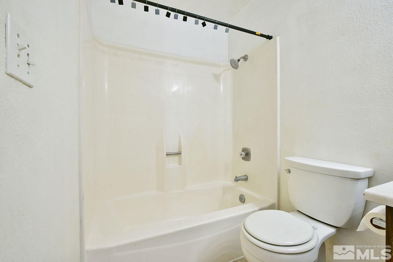 10066 Atwood Street Reno, NV 89506 - Photo 15 of 23 a white toilet sitting next to a bath tub