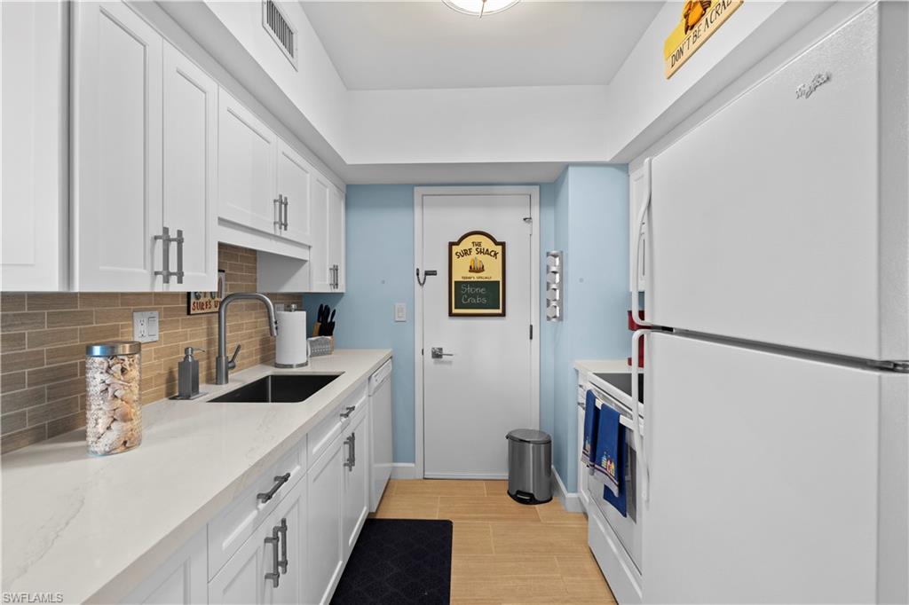 240 Seaview Court, Unit 413 Marco Island, FL 34145 - Photo 16 of 35 a kitchen with stainless steel appliances a refrigerator a sink a stove and white cabinets