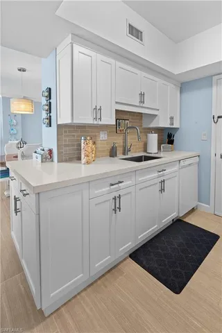 a kitchen with a sink dishwasher and cabinets