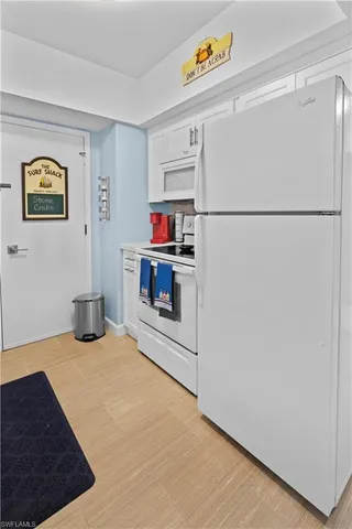 a kitchen with a refrigerator and a stove top oven