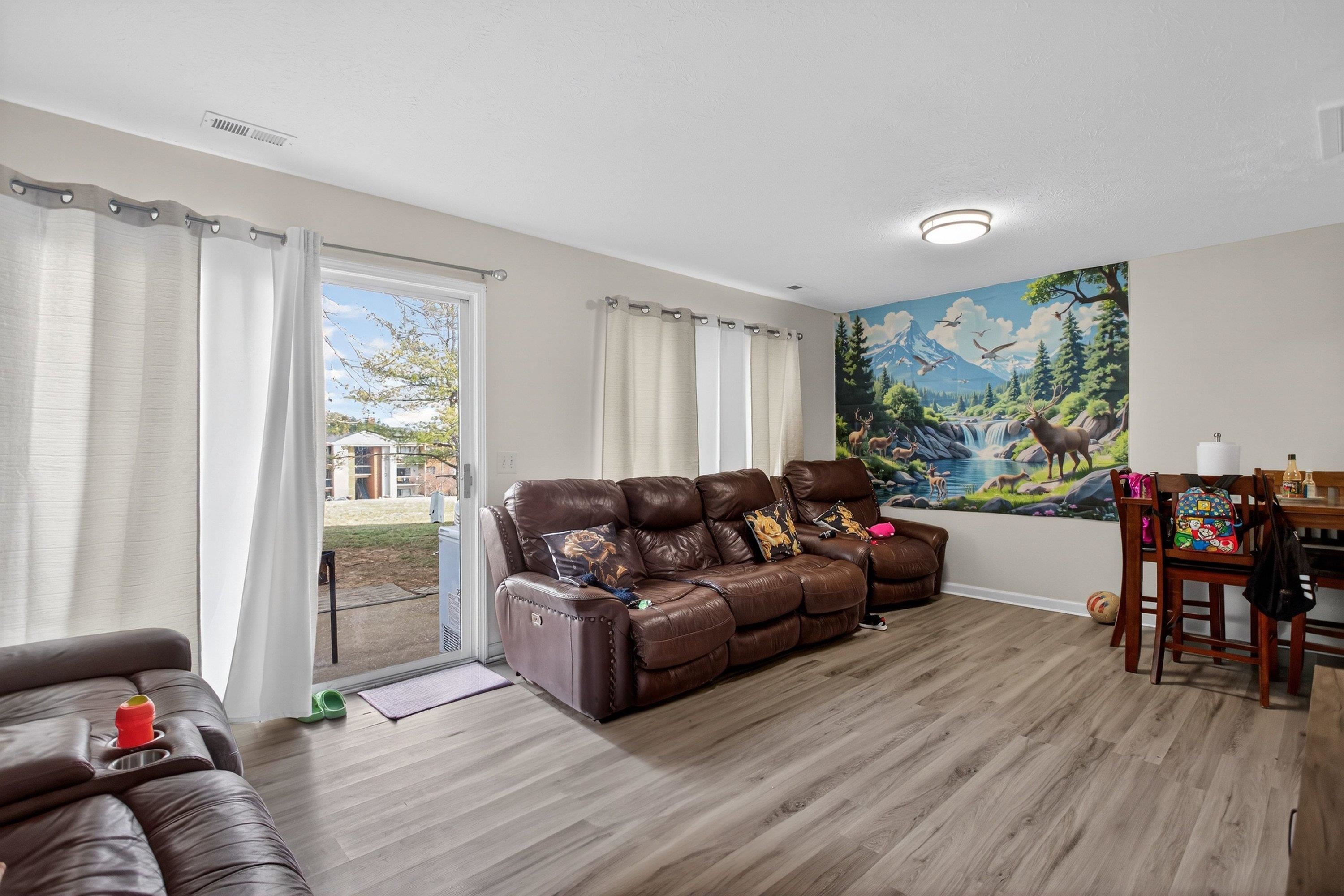 1211 Old Furnace Road Harrisonburg, VA 22802 - Photo 8 of 55 The very large living room offers an expansive area featuring luxury vinyl plank flooring and large patio doors leading to the rear of the home. This living room space opens up to the kitchen and dining area.