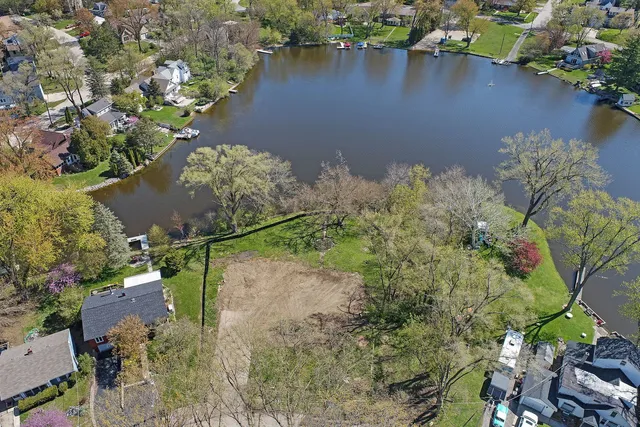 an aerial view of a house with a yard and lake view